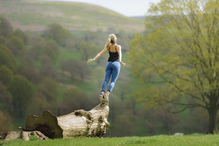 Frei sein - Atem befreien. Frau streckt sich und atmet die Natur